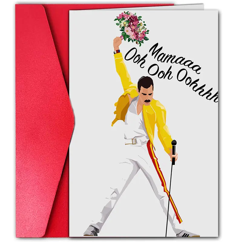 Mother’s Day greeting card featuring an illustrated figure resembling Freddie Mercury in a yellow jacket and white pants, holding a microphone in one hand and a bouquet of flowers raised high in the other. The card reads 'Mamaaa Ooh Ooh Oohhh' in black script. A bright red envelope is placed behind the card, all set against a white background.
