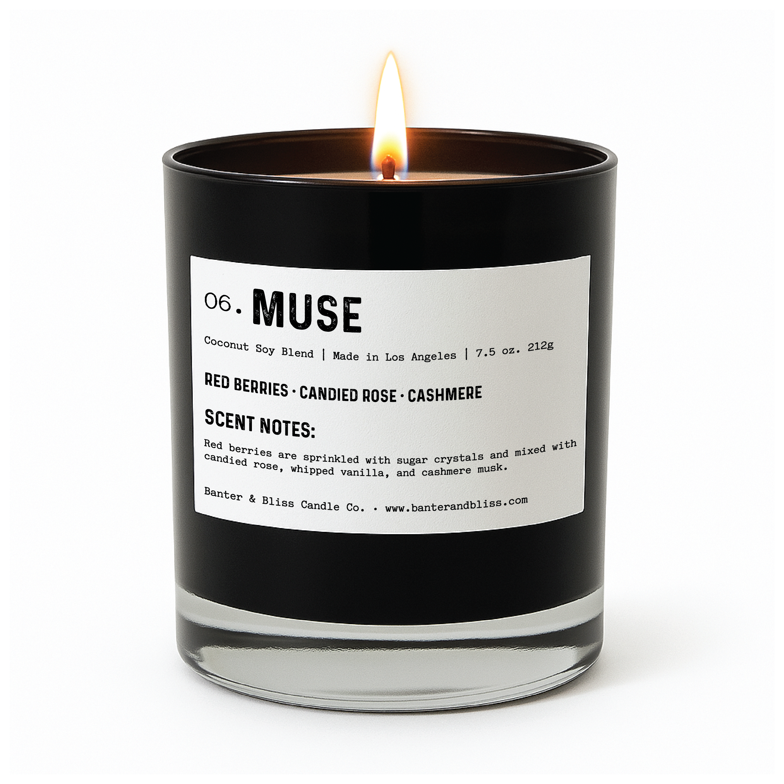 lit black glass candle labeled "06. MUSE" from Banter & Bliss Candle Co. The label describes it as a coconut soy blend made in Los Angeles, weighing 7.5 oz (212g). The scent includes red berries, candied rose, and cashmere. The scent notes mention red berries sprinkled with sugar crystals, mixed with candied rose, whipped vanilla, and cashmere musk.