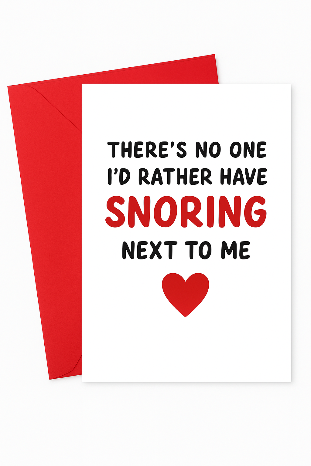 A white greeting card placed on top of a red envelope, set against a clean white background. The card features bold black and red text that reads: "THERE’S NO ONE I’D RATHER HAVE SNORING NEXT TO ME," with the word “SNORING” and a heart symbol in red for emphasis.