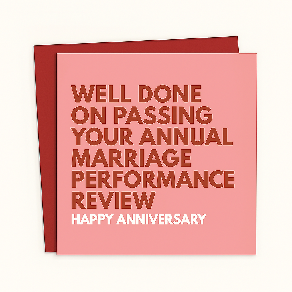 A square-shaped pink anniversary card placed on top of a red envelope. The card features bold, dark red text that reads, WELL DONE ON PASSING YOUR ANNUAL MARRIAGE PERFORMANCE REVIEW" and white text at the bottom that says, "HAPPY ANNIVERSARY." The background is a clean white.