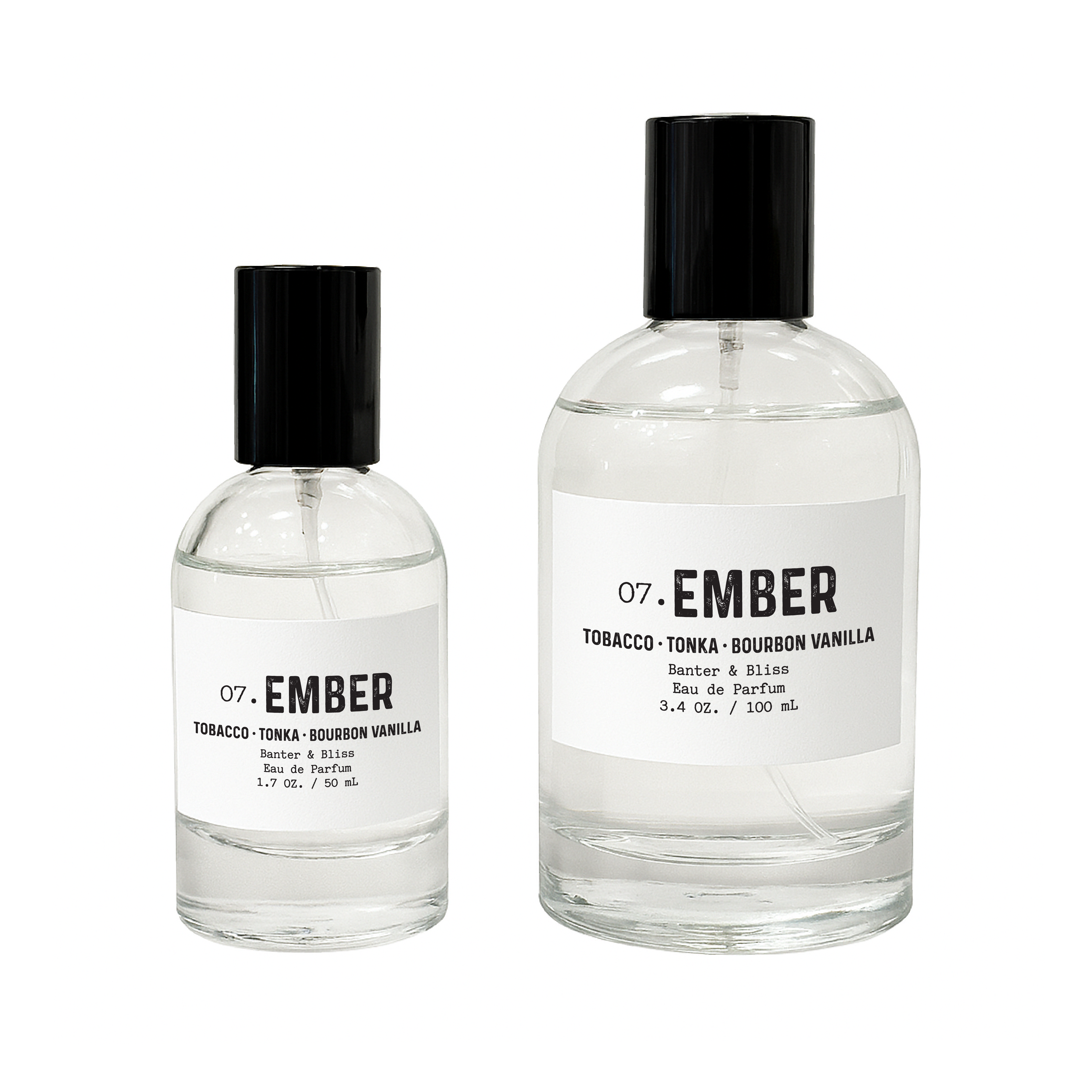 Two clear glass perfume bottles labeled "Ember" by Banter & Bliss are displayed on a white background. The smaller 1.7 oz bottle features scent notes of tobacco, tonka, and bourbon vanilla, while the larger 3.4 oz bottle highlights amberwood, jasmine, and vanilla orchid. A luxurious eau de parfum duo designed to evoke warmth, sensuality, and depth—ideal for showcasing a gender-neutral, premium fragrance.