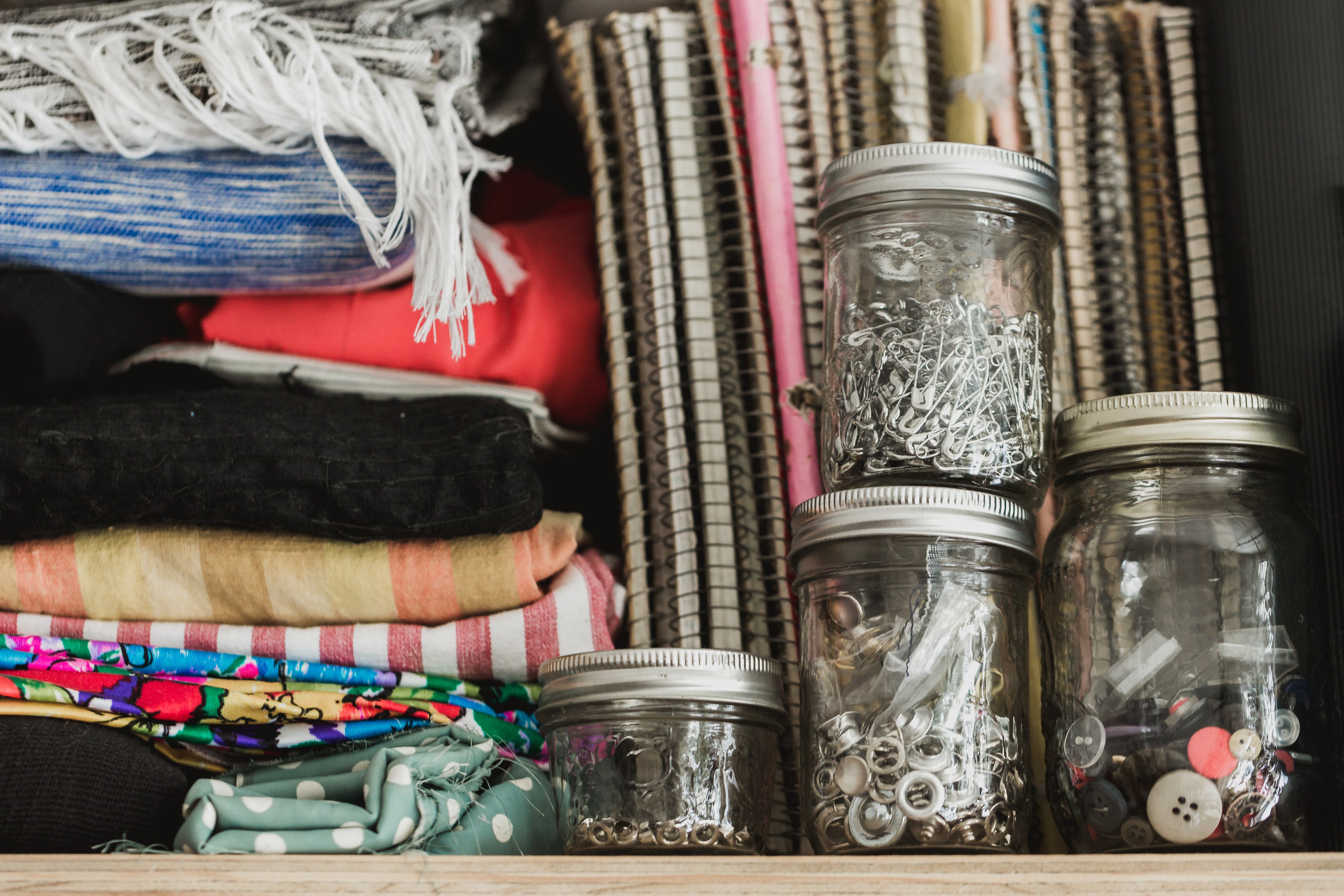 Picture Showing Candle Jars being Repurposed to Store Sewing Supplies