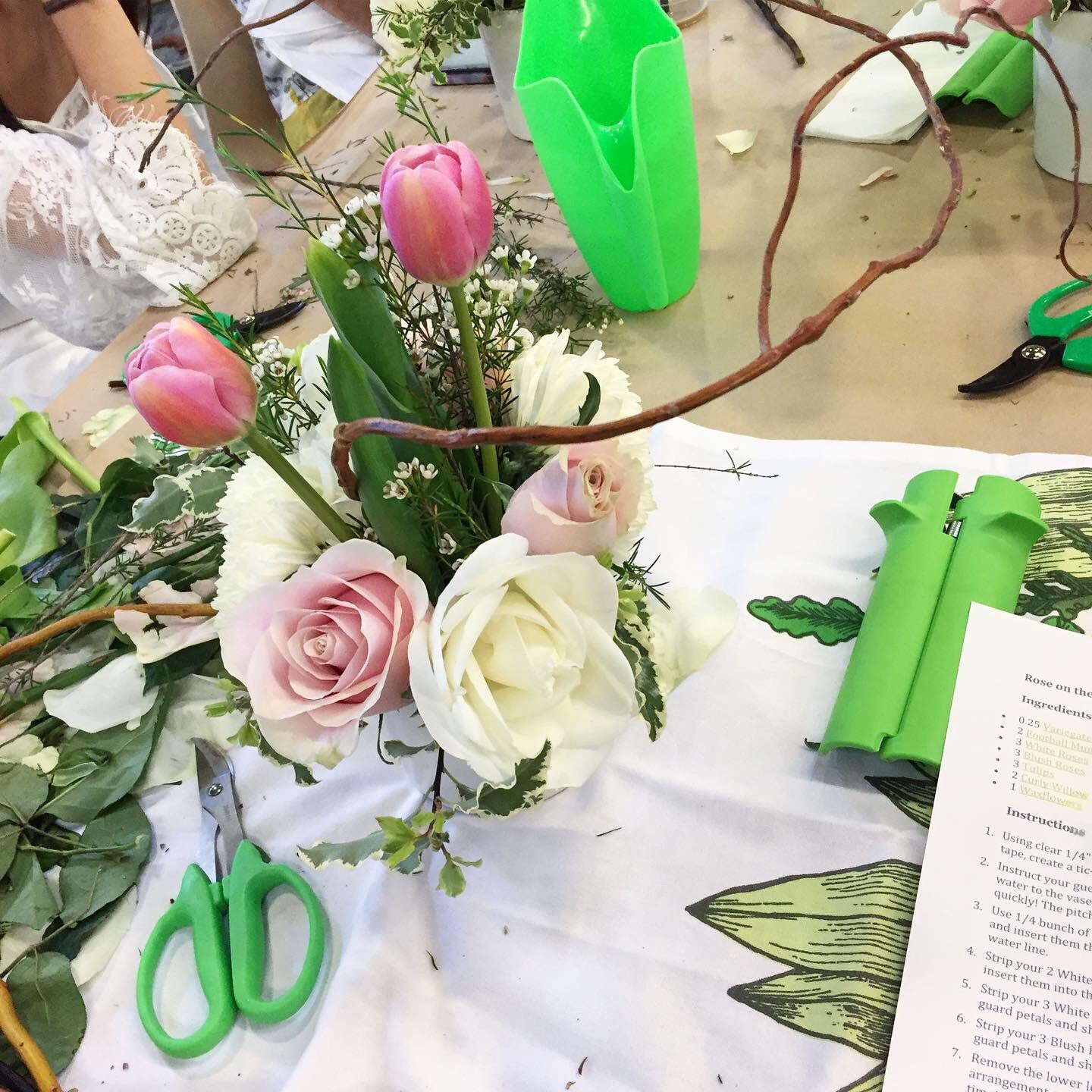 Flower arranging class in session at Banter & Bliss workshop, supplies and tools on a table